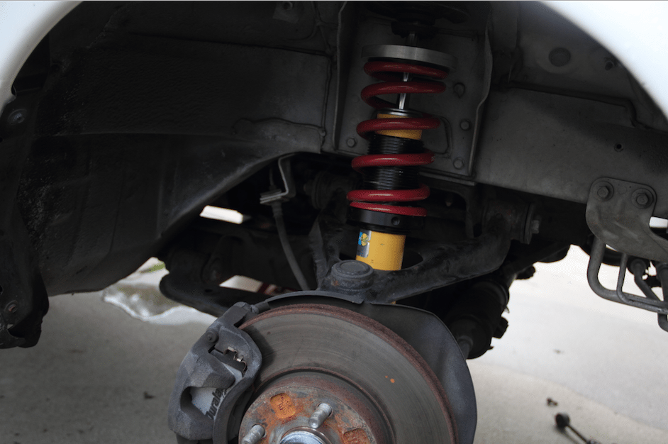 Start by measuring the static dimension from the top of each wheel to the fender edge. Then, with the car up on four jack stands, remove the springs and anti-roll bar links at all four corners. 