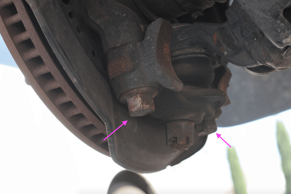 Break loose the two bolts attaching the ball joint to the spindle. Do not touch the center nut on the actual ball joint itself. Just the two bolts on the ball joint mount.
