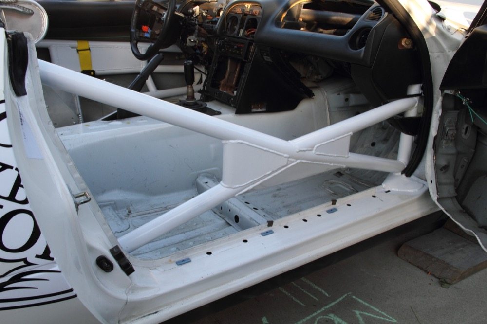 The passenger side door bar is a pyramid X design, which directs the load during a side collision to the front and rear hoop. The pyramid X also provides room for a passenger seat and is lighter than a traditional NASCAR bar.