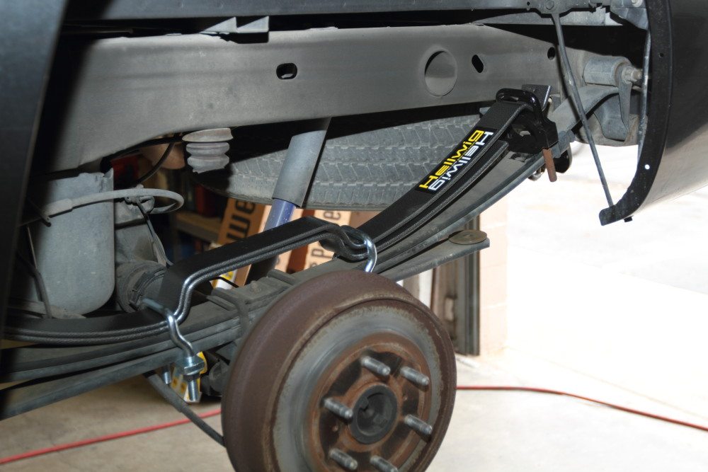This photo shows several steps combined into one. Lay the Pro Series springs atop the OEM leaves and place the black silencer bushings on the ends. Once everything is in place, position the U bolts as shown. Be sure the long end of the springs are installed at the rear of the truck, and that the offset U bolts angle toward the axle, not away from it. 