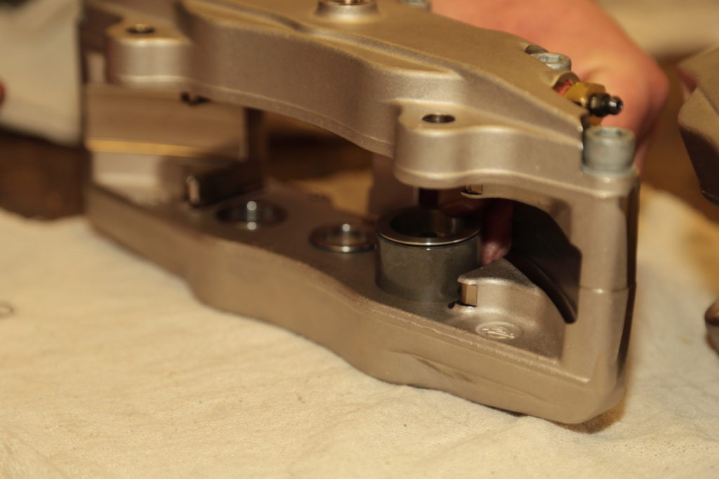 Bushman inserts the piston into the caliper bore. Note how the Wilwood caliper uses different diameter pistons, which helps prevent pad taper in heavy-braking applications.